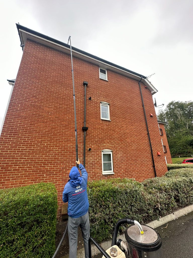 Go West window cleaner using a water-fed pole in Whitstable